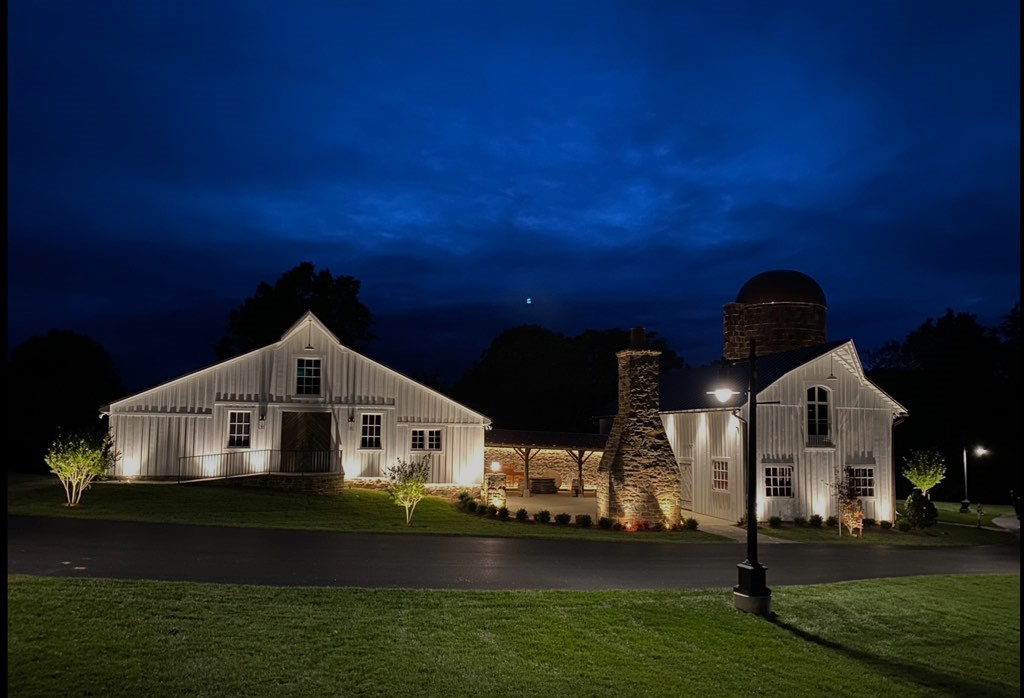 Barn on grass at night with lights